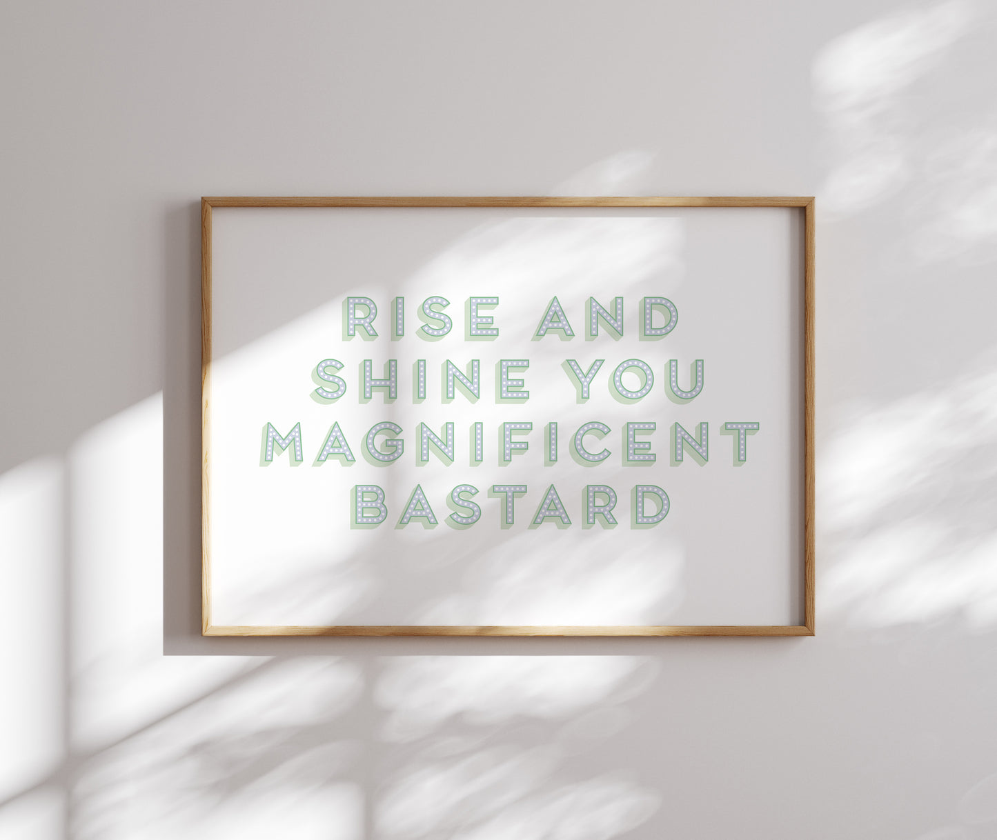 The 'Rise and Shine You Magnificent Bastard' wall art adding humour to a modern bedroom interior.